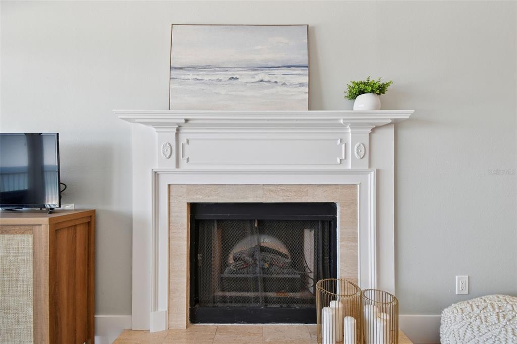 1586 Gulf Boulevard, Unit 2502 Clearwater Beach, FL 33767 - Photo 26 of 47 a living room with a fireplace and a flat screen tv