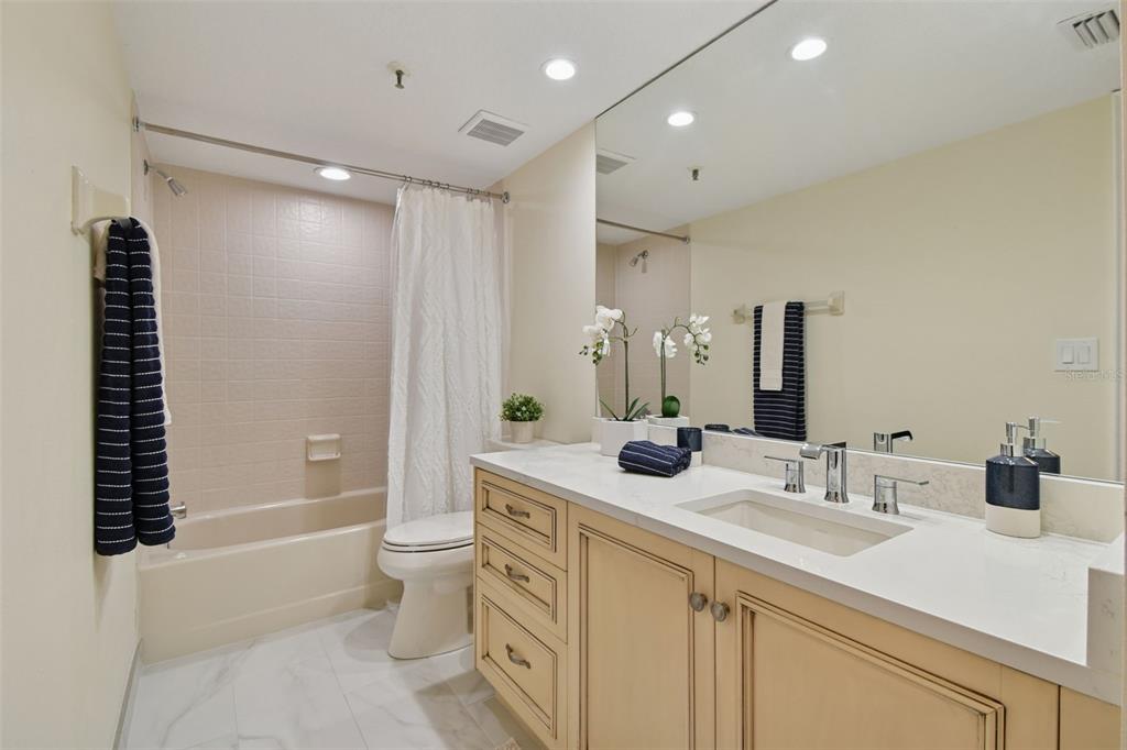 1586 Gulf Boulevard, Unit 2502 Clearwater Beach, FL 33767 - Photo 30 of 47 a bathroom with a double vanity sink toilet and shower