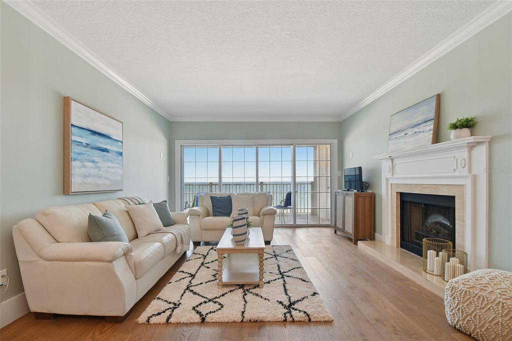 1586 Gulf Boulevard, Unit 2502 Clearwater Beach, FL 33767 - Photo 3 of 47 a living room with furniture and a fireplace