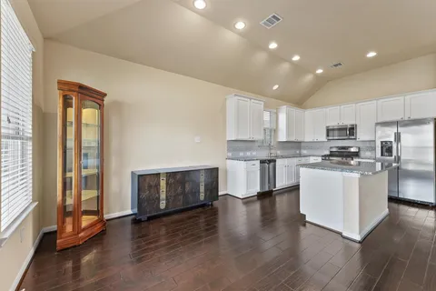 a kitchen with a refrigerator and a stove top oven