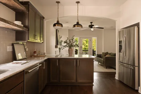 a large kitchen with stainless steel appliances wooden floors and wooden cabinets
