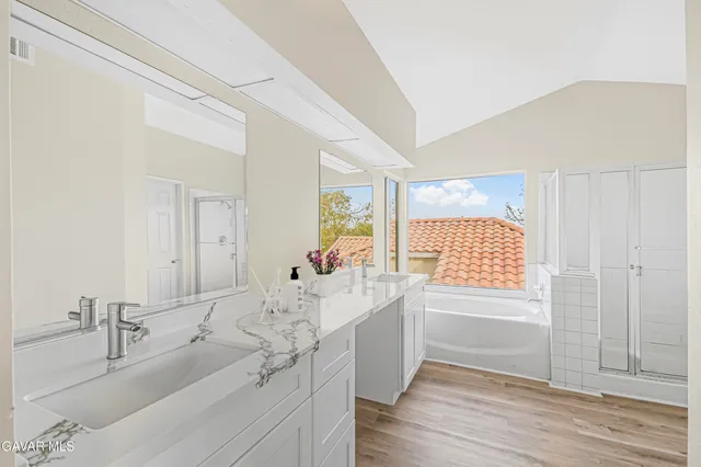 a bathroom with a granite countertop sink mirror and bathtub