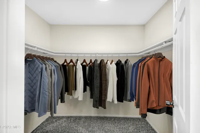 a view of walk in closet with clothes