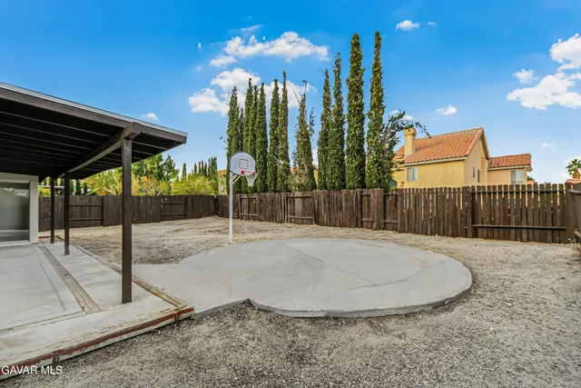 a view of a backyard with wooden fence