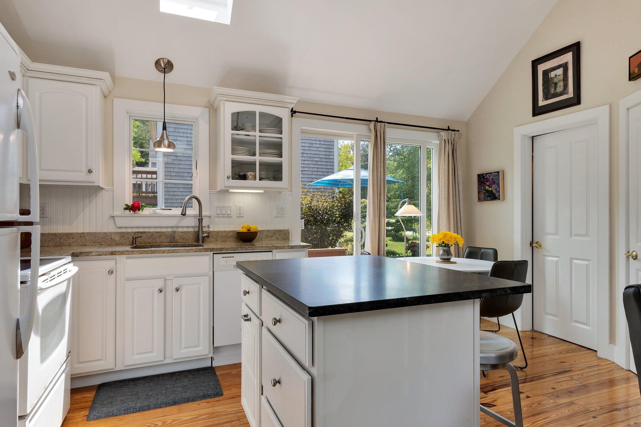6 Shore Road, Unit 10 Truro, MA 02666 - Photo 11 of 37 a kitchen with sink cabinets and wooden floor