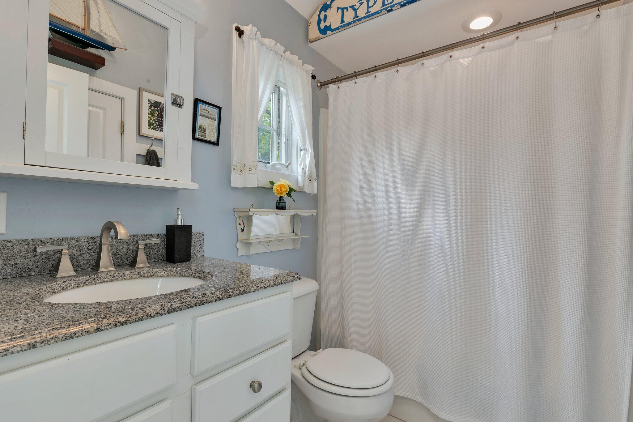6 Shore Road, Unit 10 Truro, MA 02666 - Photo 17 of 37 a bathroom with a granite countertop sink and a mirror