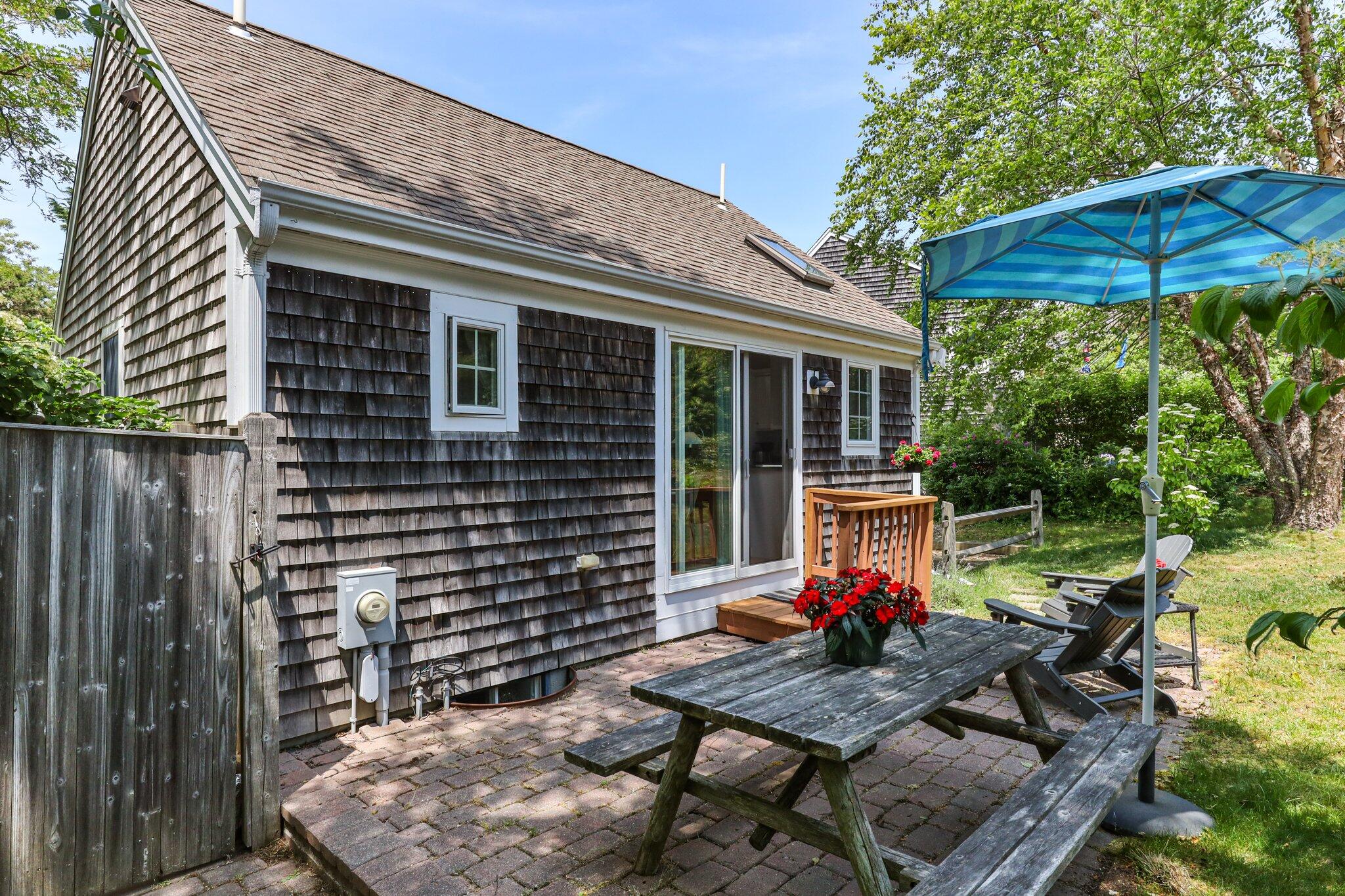 6 Shore Road, Unit 10 Truro, MA 02666 - Photo 26 of 37 a view of a patio with table and chairs under an umbrella