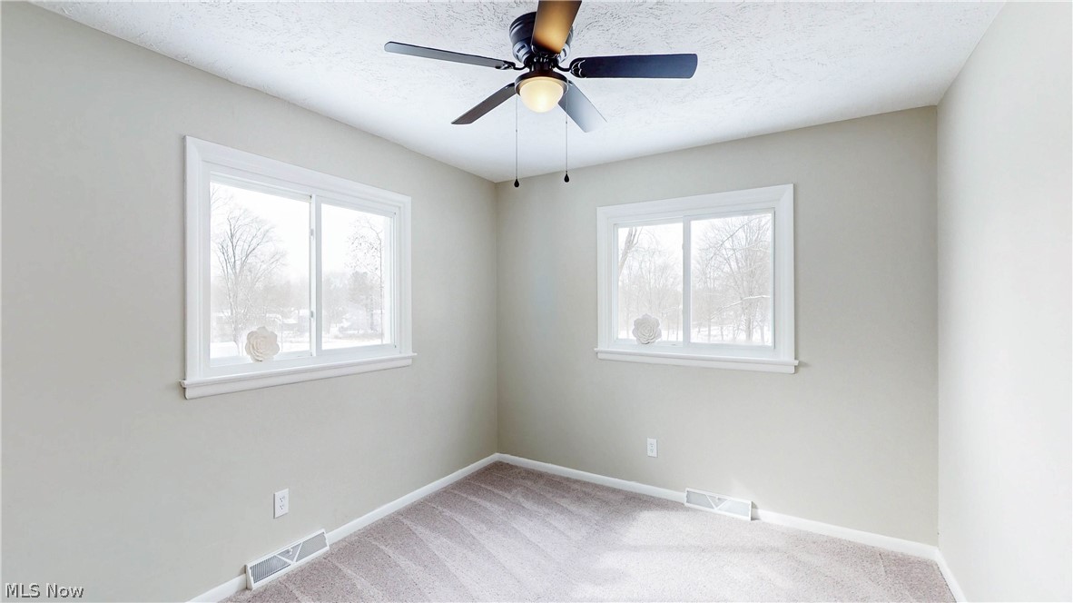 3312 Bancroft Road Akron, OH 44333 - Photo 26 of 50 Empty room featuring ceiling fan, light colored carpet, and a textured ceiling