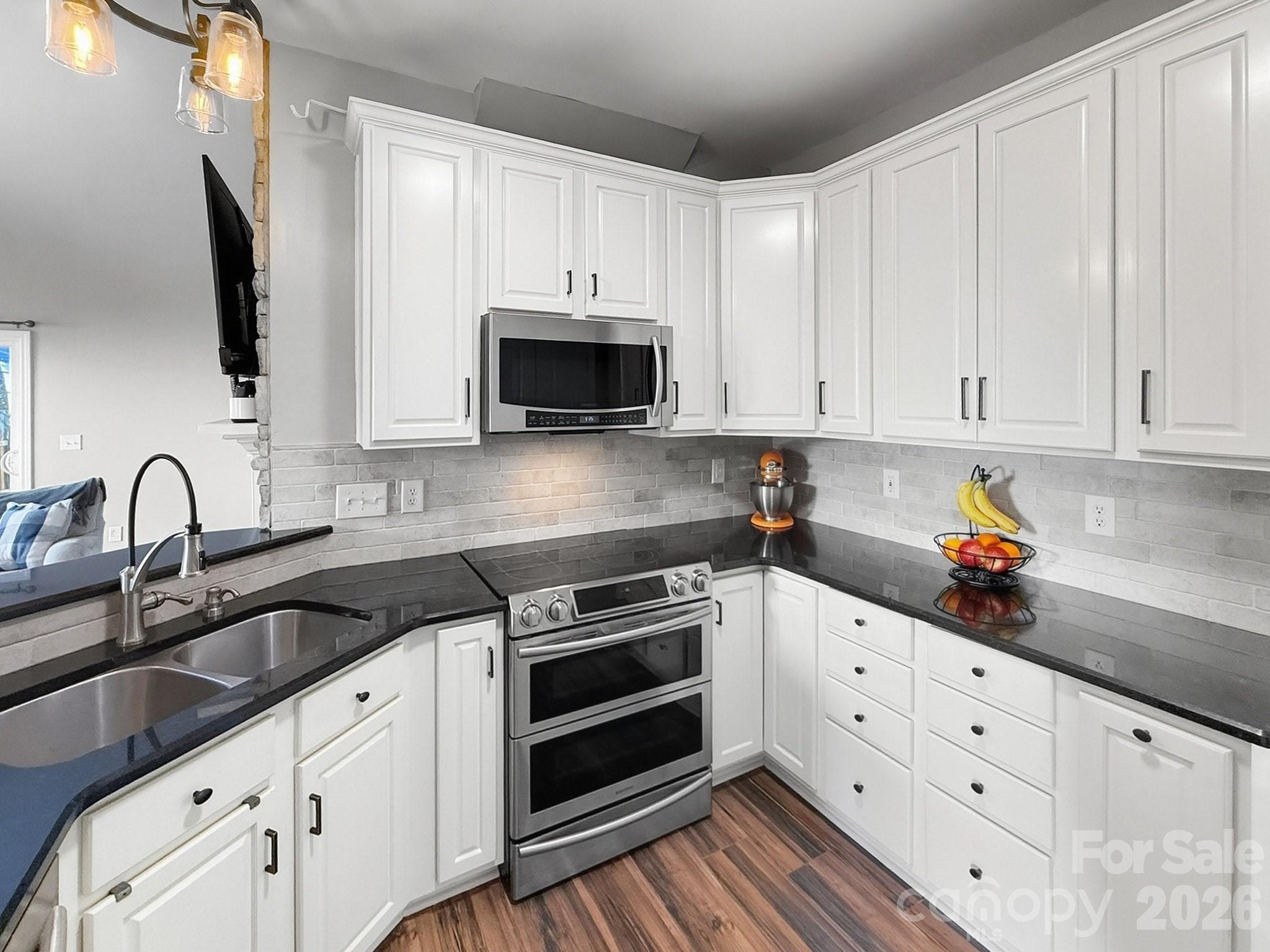 179 Whitley Mills Road, Unit 44 Fort Mill, SC 29708 - Photo 9 of 25 a kitchen with granite countertop white cabinets and stainless steel appliances