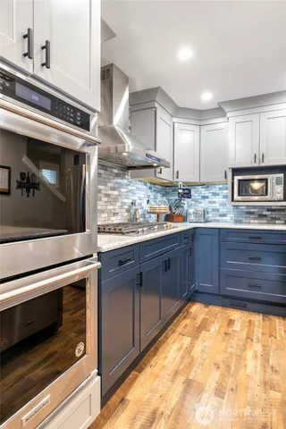 a kitchen with stainless steel appliances granite countertop a stove a sink and a microwave