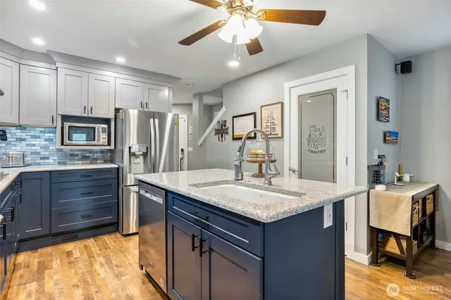 a kitchen with kitchen island granite countertop a sink stove and refrigerator