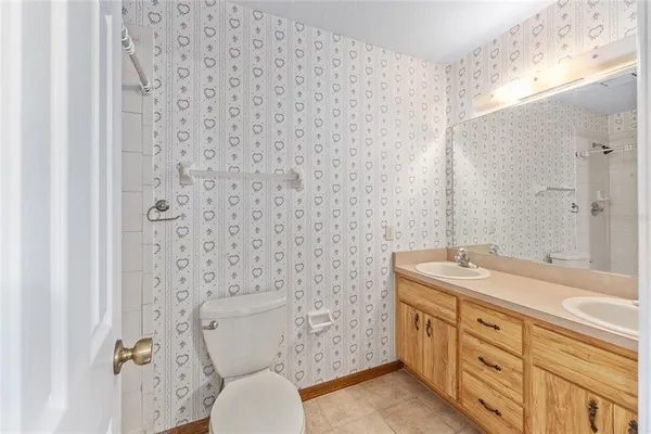 a bathroom with a granite countertop toilet a sink and a mirror