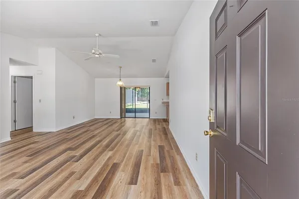 a view of a room with wooden floor staircase and a kitchen