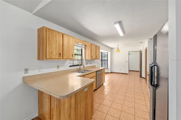 a kitchen with stainless steel appliances granite countertop a sink and a refrigerator
