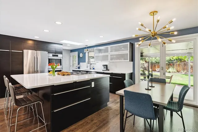 a kitchen with a dining table chairs stainless steel appliances and cabinets