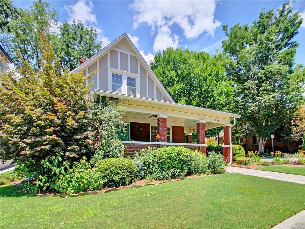 a front view of a house with a yard and trees