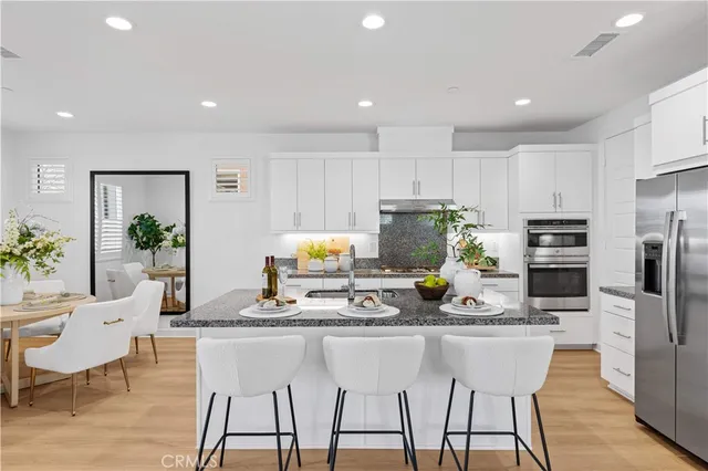 a kitchen with stainless steel appliances granite countertop a refrigerator and a stove top oven