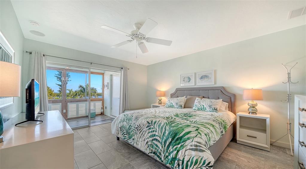 4440 Exeter Drive, Unit 301 Longboat Key, FL 34228 - Photo 13 of 72 a bedroom with a large bed and a flat tv screen on dresser