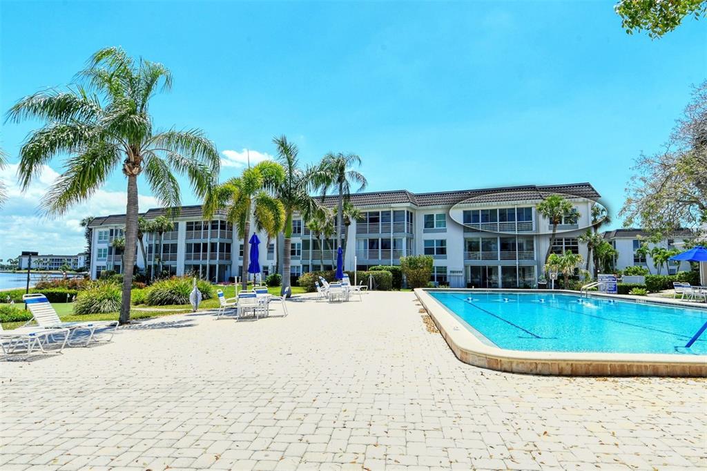 4440 Exeter Drive, Unit 301 Longboat Key, FL 34228 - Photo 27 of 72 a view of swimming pool with outdoor seating and house in the background