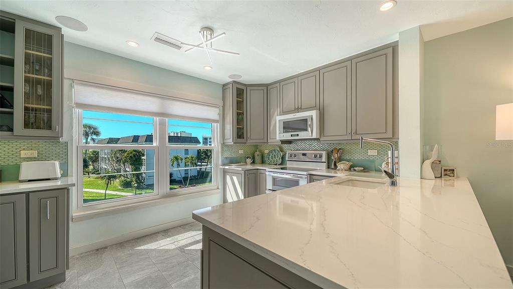 4440 Exeter Drive, Unit 301 Longboat Key, FL 34228 - Photo 8 of 72 a kitchen with sink cabinets and outdoor view