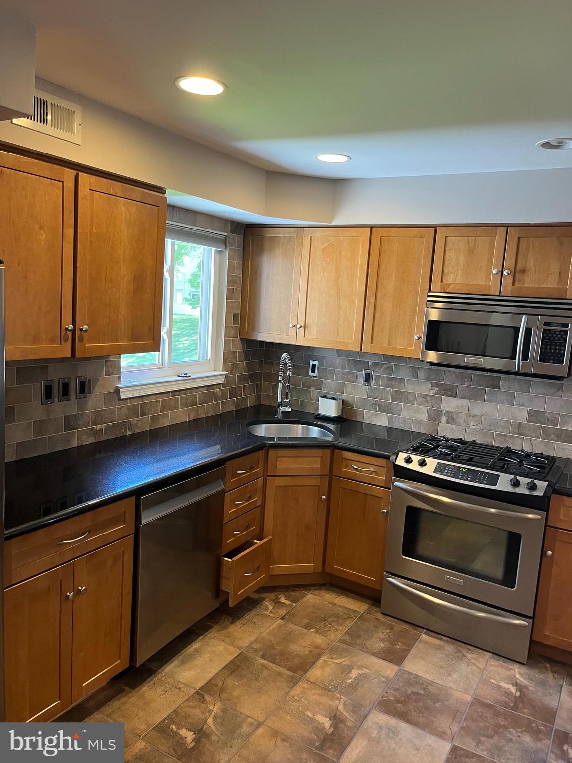 511 Chanticleer Cherry Hill, NJ 08003 - Photo 22 of 32 a kitchen with stainless steel appliances granite countertop a sink a stove and a microwave