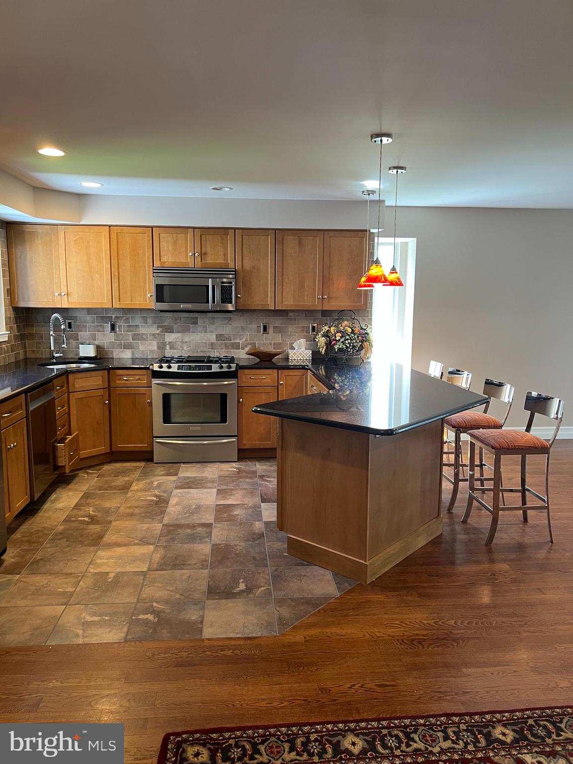 511 Chanticleer Cherry Hill, NJ 08003 - Photo 25 of 32 a kitchen with stainless steel appliances granite countertop a stove top oven a sink dishwasher and cabinets with wooden floor