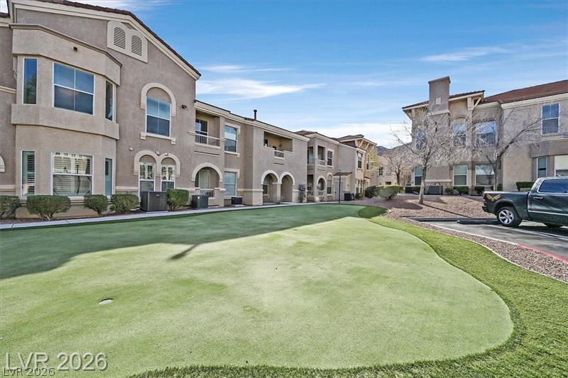 10550 West Alexander Road, Unit 2148 Las Vegas, NV 89129 - Photo 30 of 41 A community putting green offers leisure amidst tastefully designed multi-story buildings and mountain vistas.