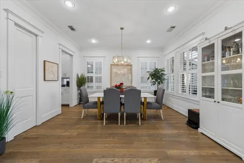a kitchen with a dining table chairs wooden floor cabinets and stainless steel appliances