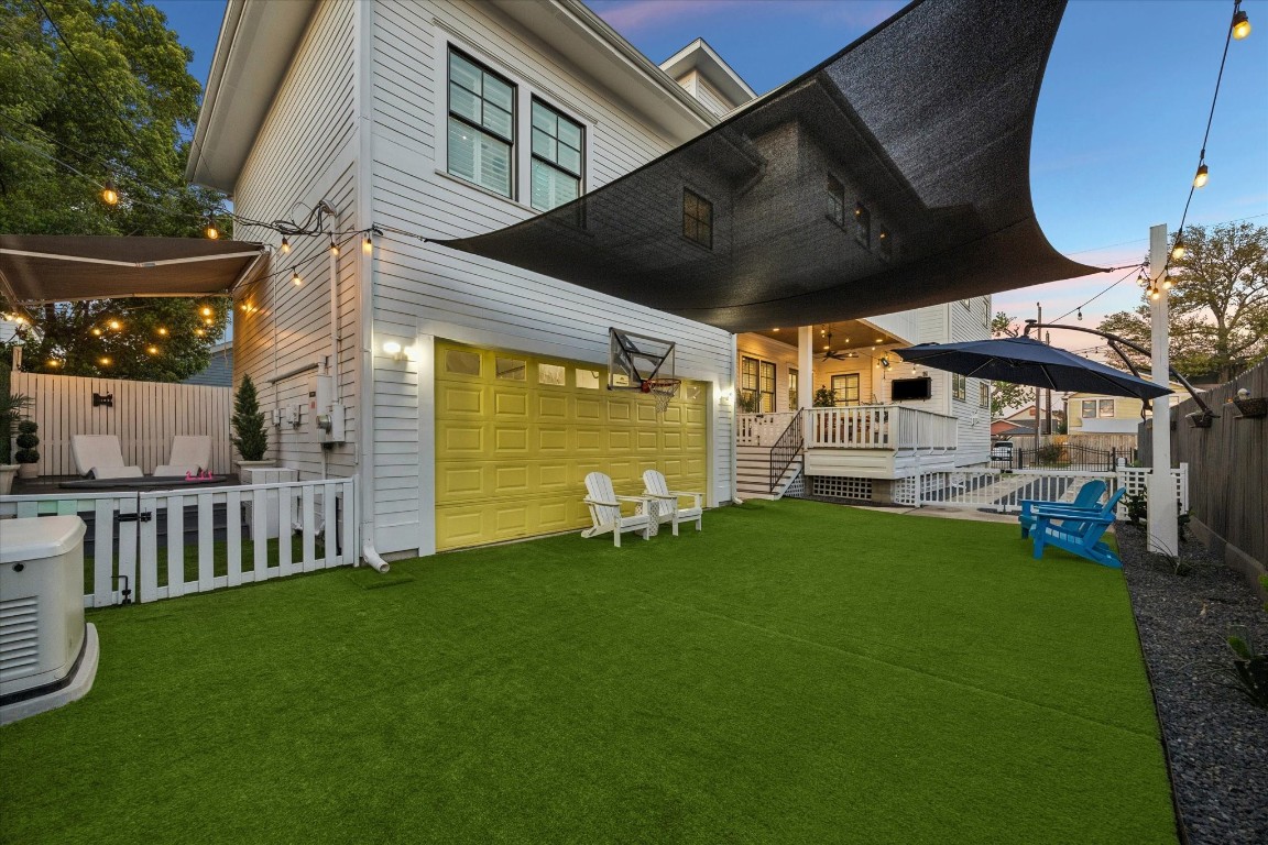 3535 Michaux Street Houston, TX 77009 - Photo 2 of 48 As the sun sets, this modern backyard with artificial turf offers a cooler, breezier space for outdoor living, and features a whimsical yellow garage door alongside the shaded areas.
