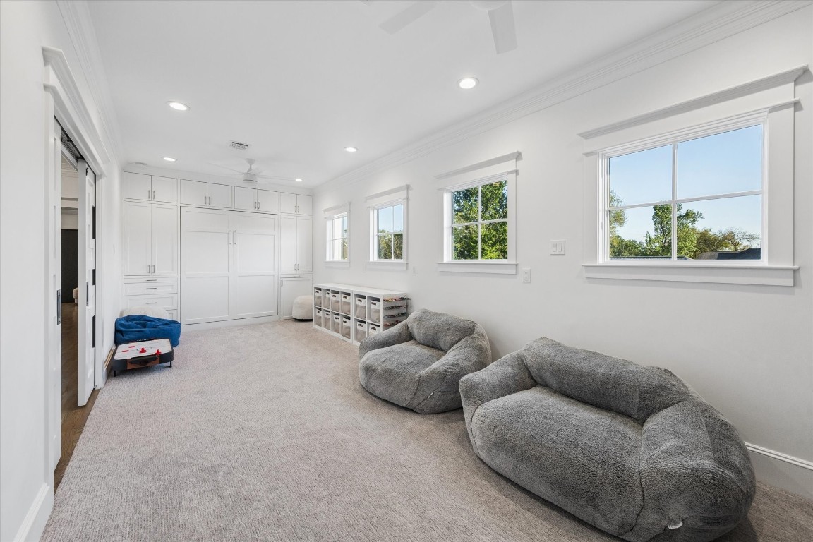 3535 Michaux Street Houston, TX 77009 - Photo 35 of 48 This room is a bright, versatile space featuring soft carpeting, a built-in murphy bed and storage cabinets, and ample natural light from two windows. Perfect for a playroom or casual living area.