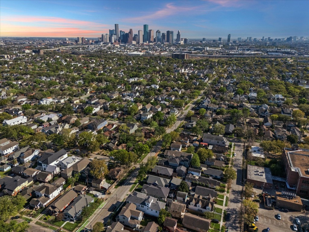 3535 Michaux Street Houston, TX 77009 - Photo 46 of 48 This aerial photo showcases a birds-eye view of the Greater Heights neighborhood with tree-lined streets and a variety of homes, set against the backdrop of Houston's skyline. This neighborhood is ideal for those wanting the vibrant Heights lifestyle, zoning to Travis elementary and convenient proximity to downtown workplaces, sports and music venues, and events.