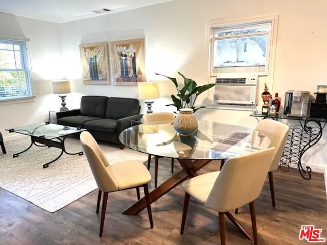 a view of a dining room with furniture a rug and wooden floor