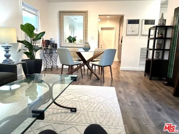 a living room with furniture a wooden floor and a potted plant