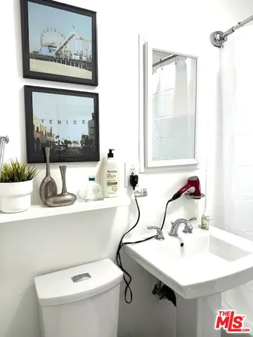 a bathroom with a sink and mirror with toilet