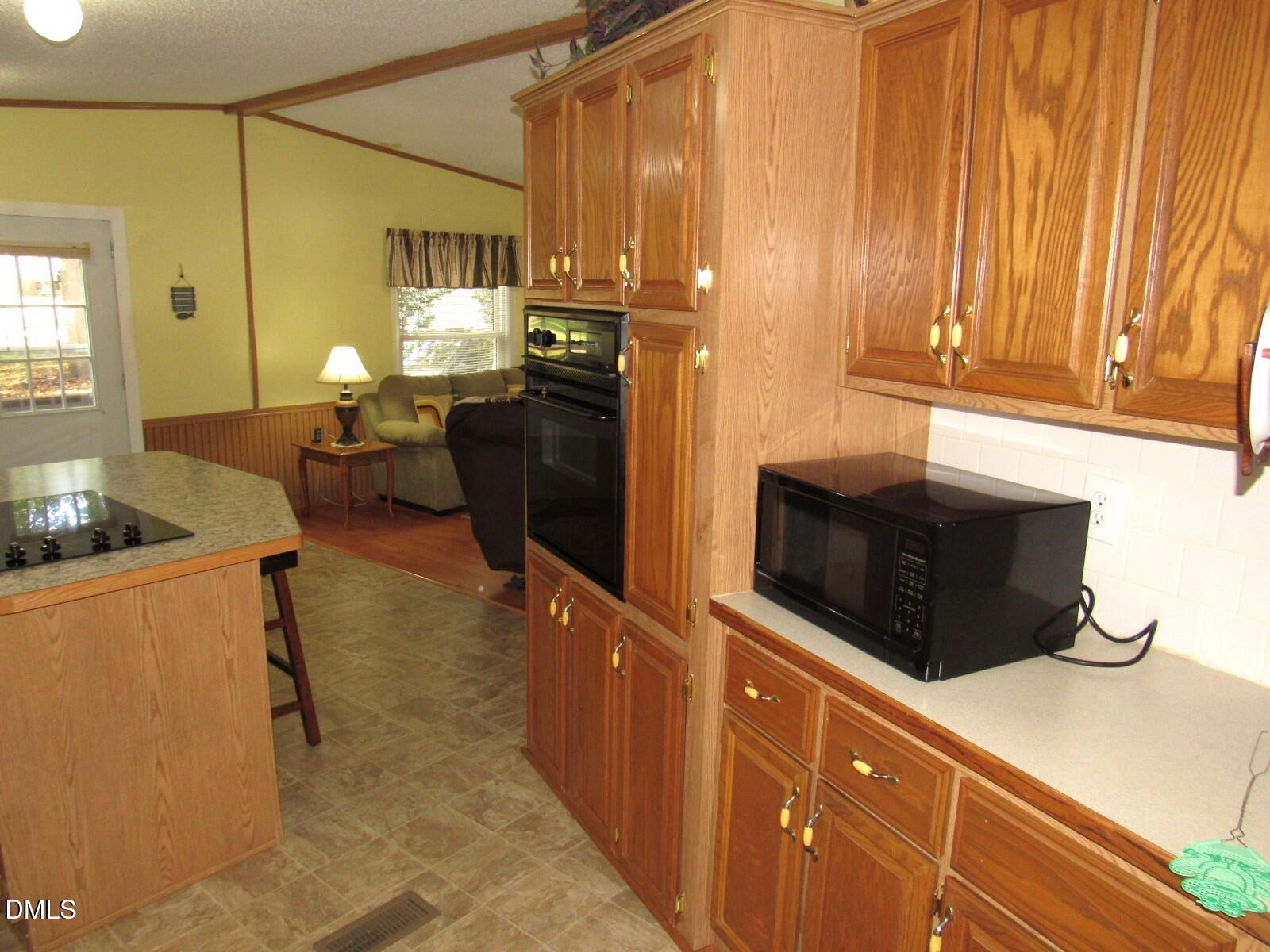 34 Waters Edge Cove Henderson, NC 27537 - Photo 13 of 44 a kitchen with stainless steel appliances wooden cabinets and a stove top oven