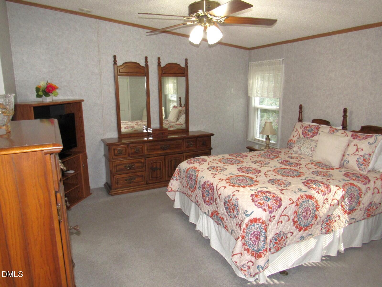 34 Waters Edge Cove Henderson, NC 27537 - Photo 19 of 44 a bedroom with a bed and a chandelier