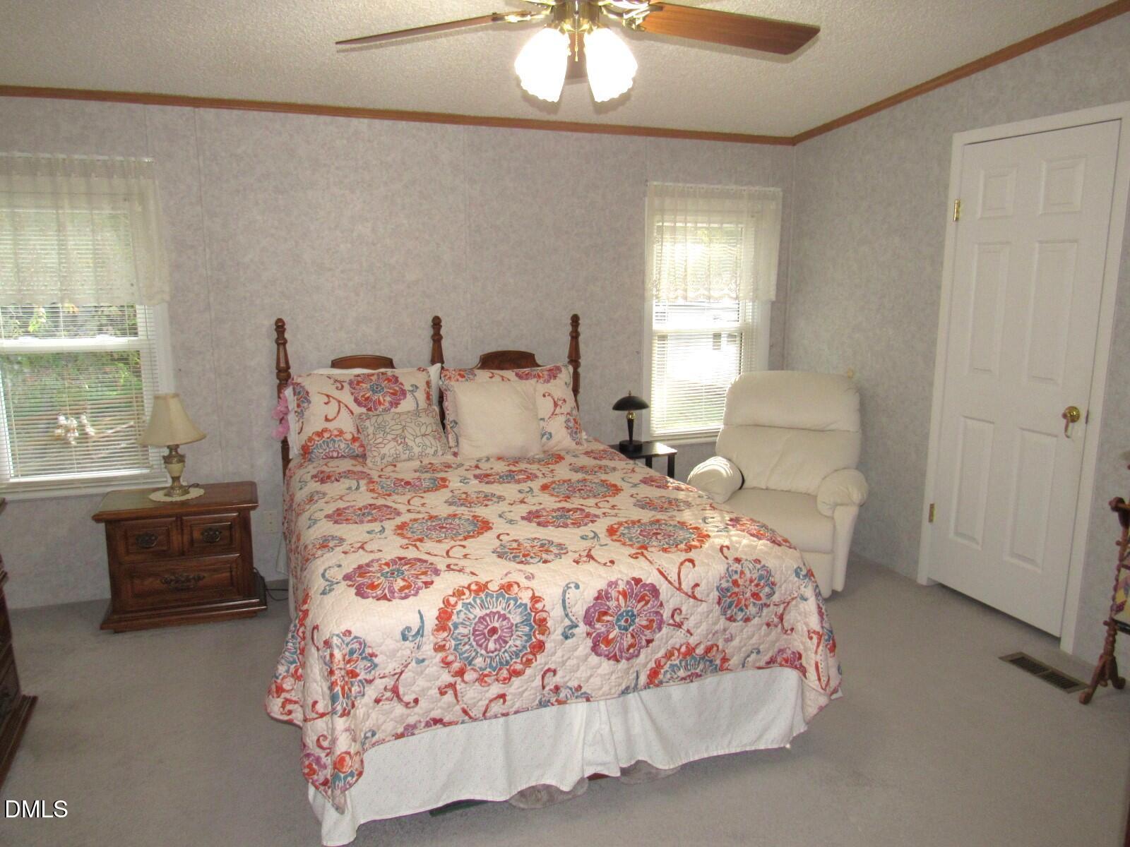 34 Waters Edge Cove Henderson, NC 27537 - Photo 20 of 44 a bedroom with a bed and a chandelier