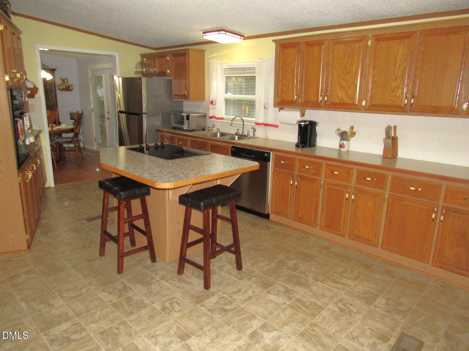 34 Waters Edge Cove Henderson, NC 27537 - Photo 10 of 44 a kitchen with stainless steel appliances granite countertop a sink a stove and a refrigerator