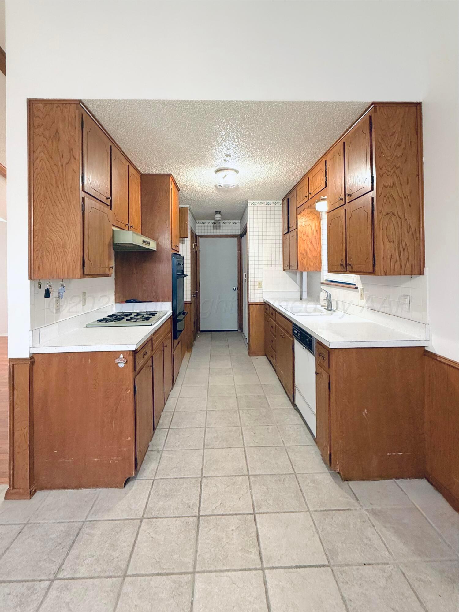 1713 Sunset Avenue Dumas, TX 79029 - Photo 7 of 15 a large kitchen with stainless steel appliances granite countertop a large counter top and stove