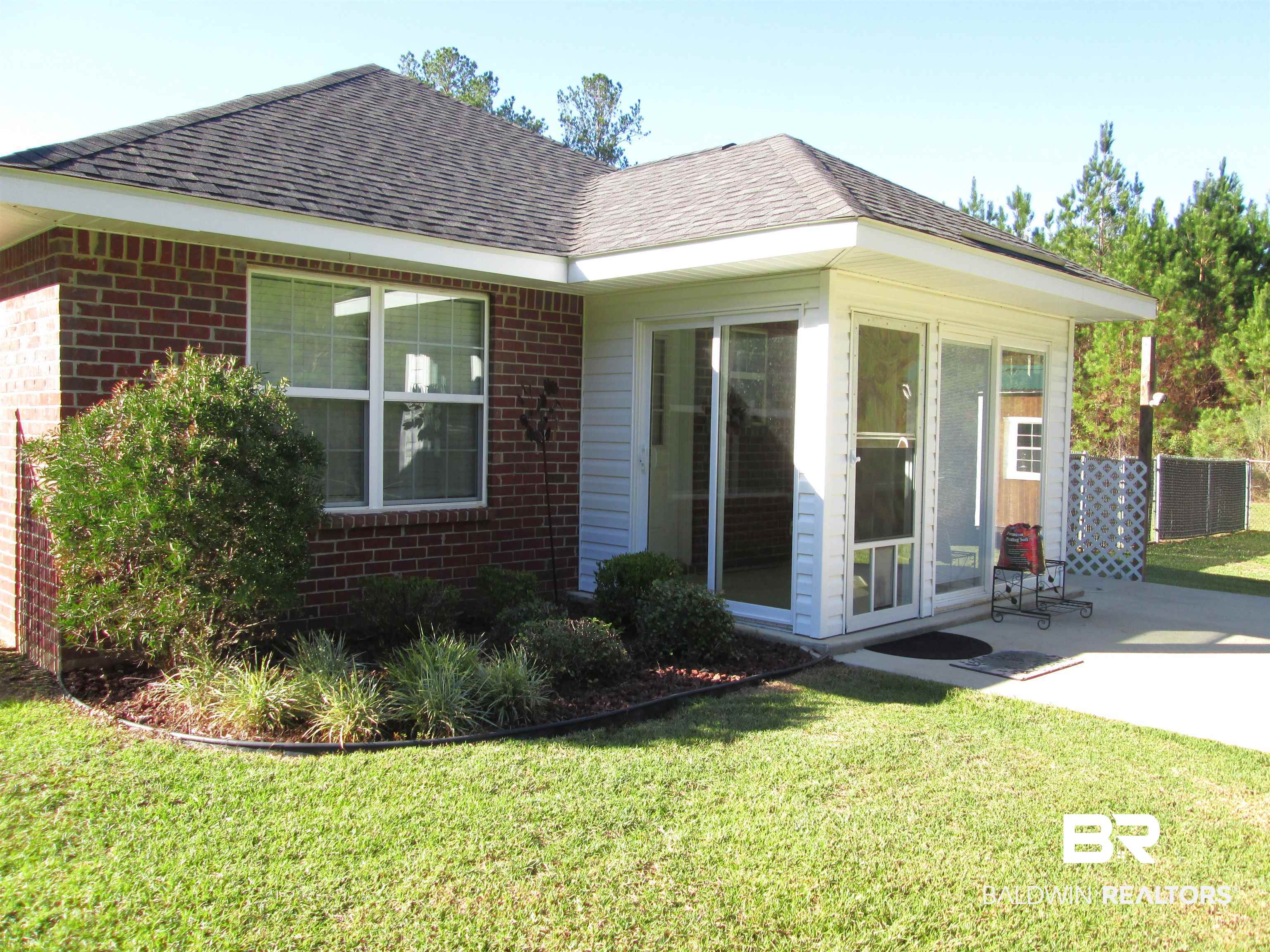 530 Brethren Church Road Fruitdale, AL 36539 - Photo 24 of 24 Rear view of house featuring a yard, a patio, and a sunroom