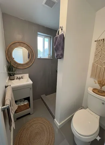 a bathroom with a toilet a sink and mirror