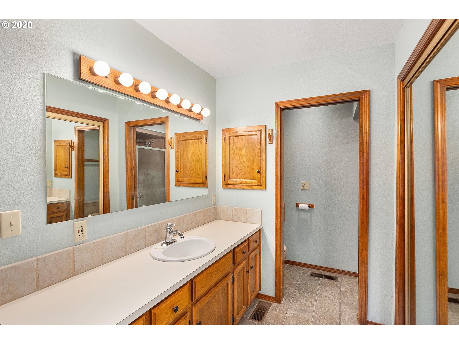 18740 Southwest Seiffert Road Sherwood, OR 97140 - Photo 13 of 32 a bathroom with a double vanity sink and a mirror
