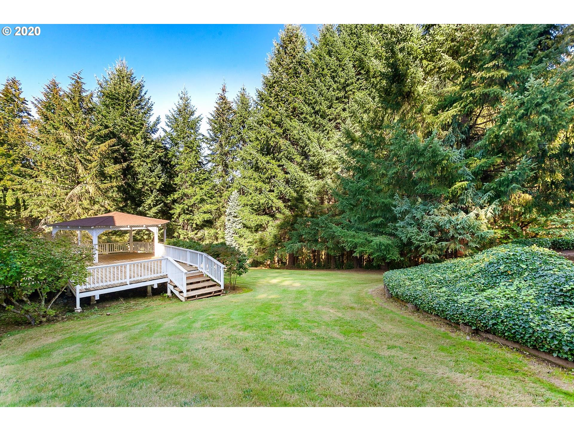 18740 Southwest Seiffert Road Sherwood, OR 97140 - Photo 25 of 32 a backyard of a house with wooden floor and large trees