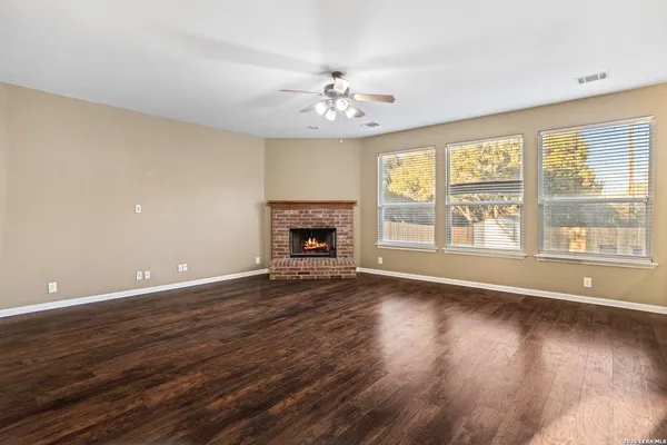 a view of a livingroom with wooden floor a fireplace and window