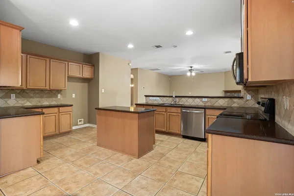 a kitchen with granite countertop a stove sink and microwave
