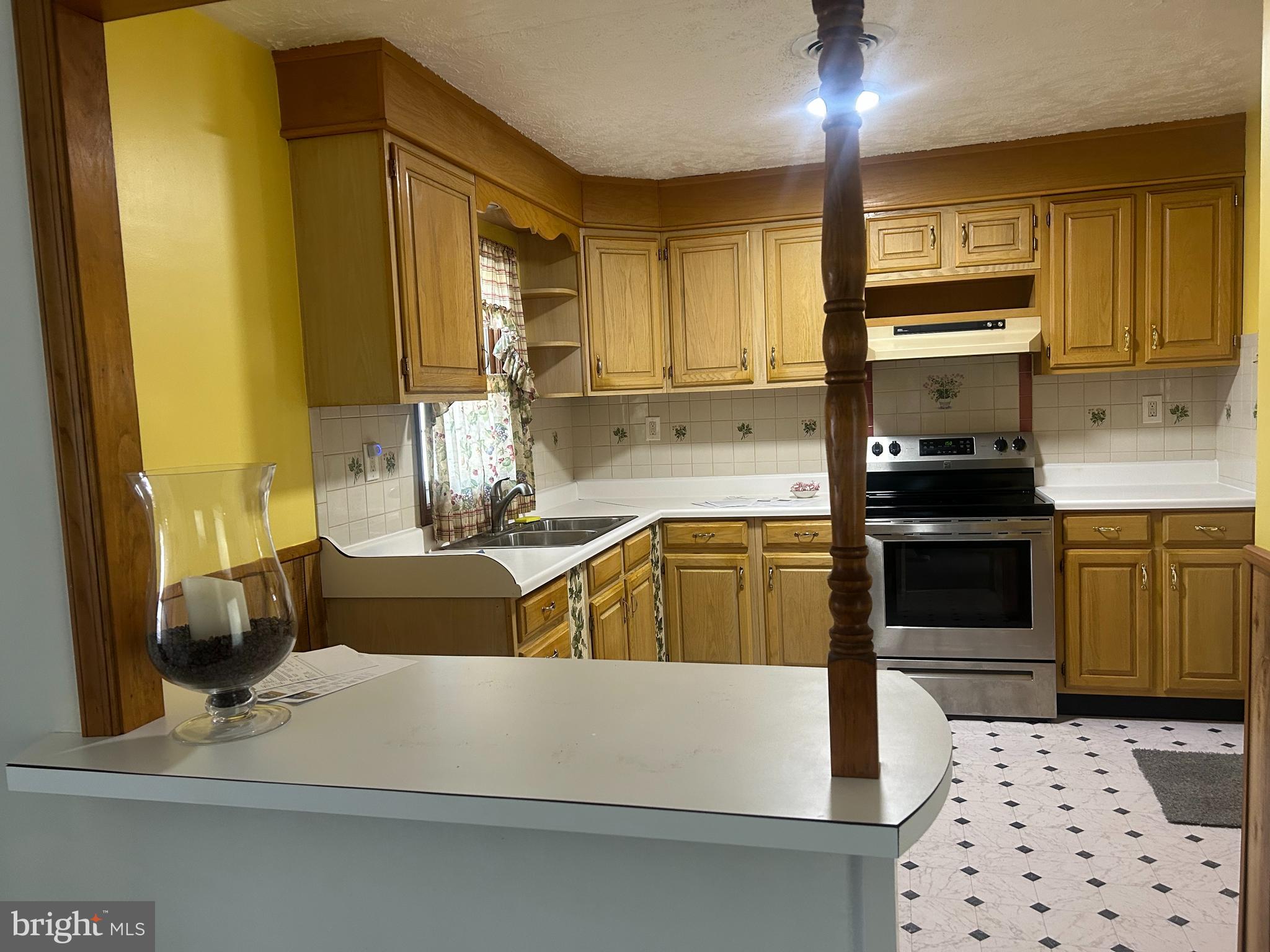 304 Barksdale Road Joppa, MD 21085 - Photo 24 of 24 a kitchen with stainless steel appliances a stove a sink a refrigerator white cabinets and wooden floor