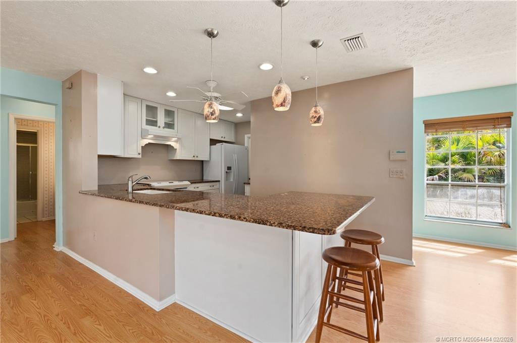 2493 Southwest Murphy Road Palm City, FL 34990 - Photo 16 of 50 a open kitchen with stainless steel appliances granite countertop a stove a sink and a refrigerator