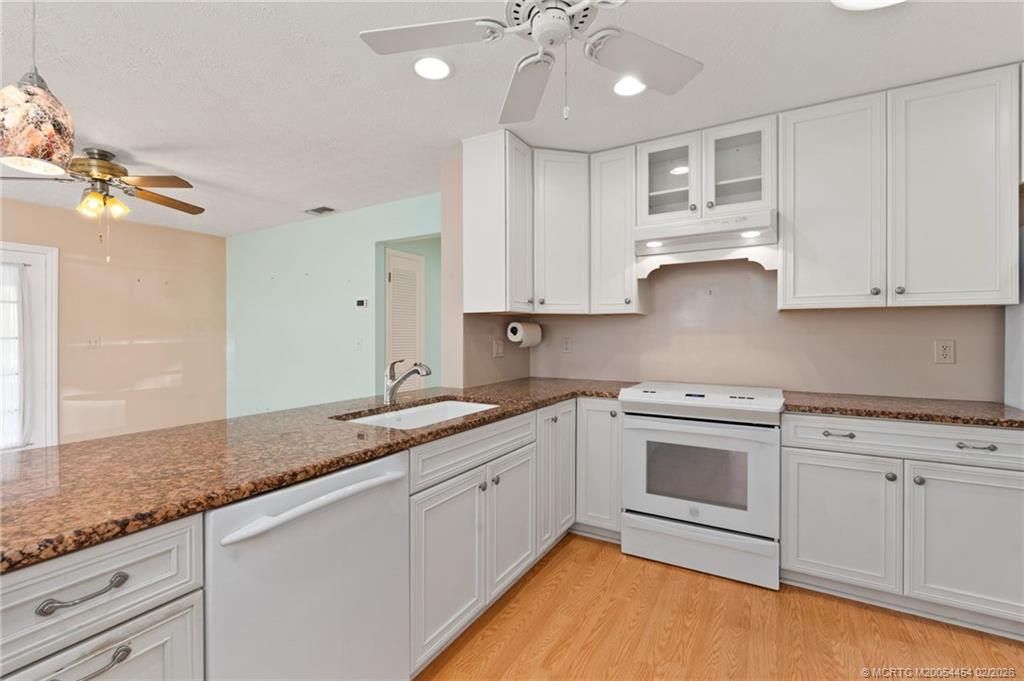 2493 Southwest Murphy Road Palm City, FL 34990 - Photo 17 of 50 a kitchen with granite countertop cabinets stainless steel appliances and a sink