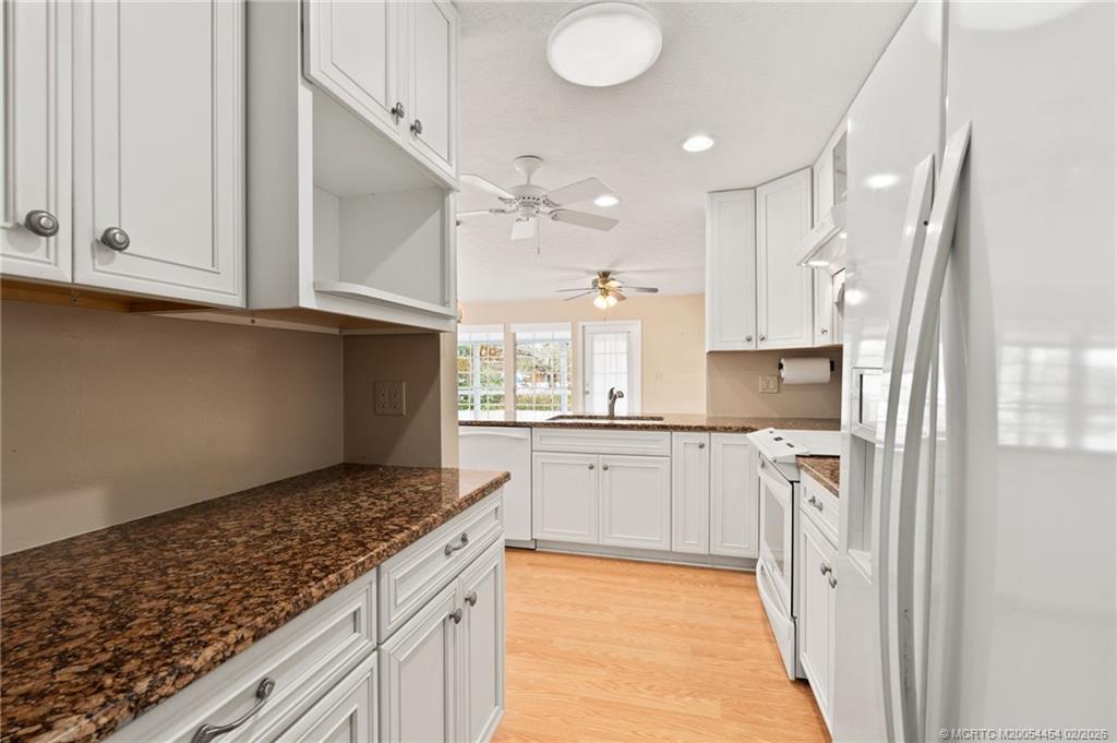 2493 Southwest Murphy Road Palm City, FL 34990 - Photo 18 of 50 a kitchen with stainless steel appliances granite countertop a refrigerator sink and cabinets