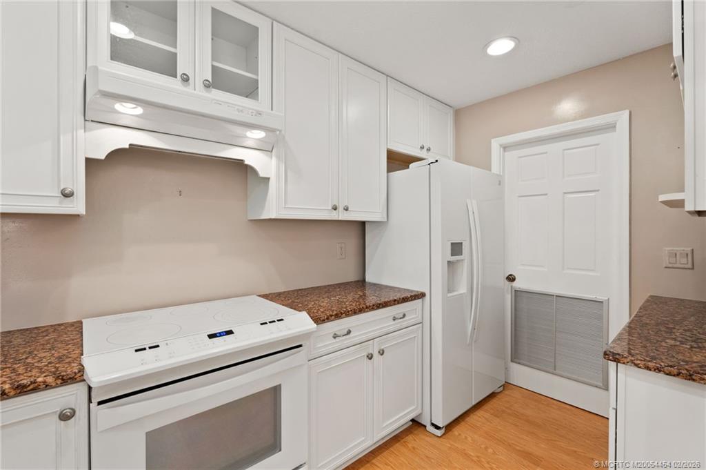 2493 Southwest Murphy Road Palm City, FL 34990 - Photo 20 of 50 a kitchen with white cabinets and white appliances